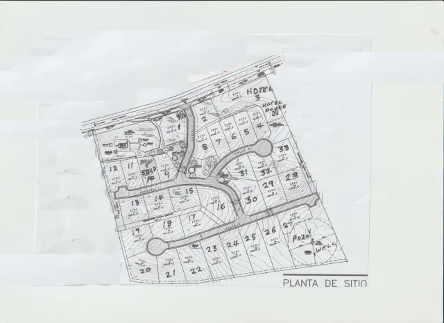 Site plan showing the layout of numbered plots, roads, and surrounding areas.