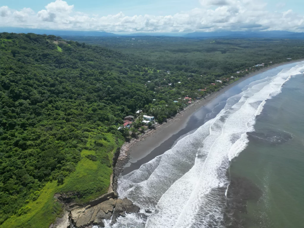 Aerial view of the Tivives coastline, tropical dry forest running down to the beach